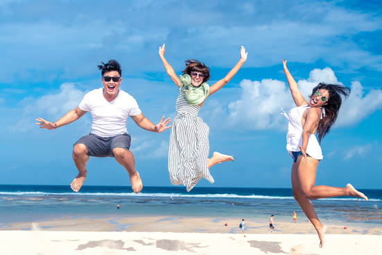 Group of multiracial friends having fun on the beach of tropical Bali island.